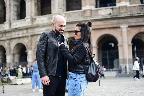 Happy Beautiful Tourists couple traveling at Rome, Italy, poses in front of Colosseum at, Rome, Italy