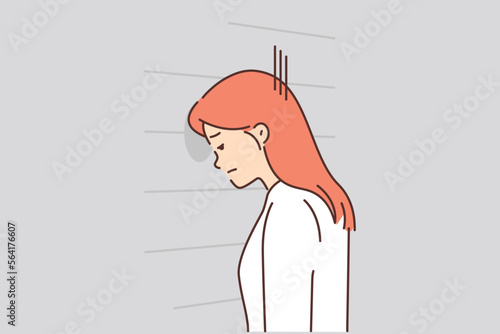 Upset woman banging her head against wall 