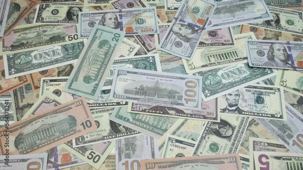A hundred dollars, ten dollars, fifty dollars, one dollar are scattered on the table. American bills. A lot of money fills the simple people in the picture. A hundred dollars, ten dollars, fifty dollars, one dollar are scattered on the table. American bills. A lot of money fills the simple people in the picture.