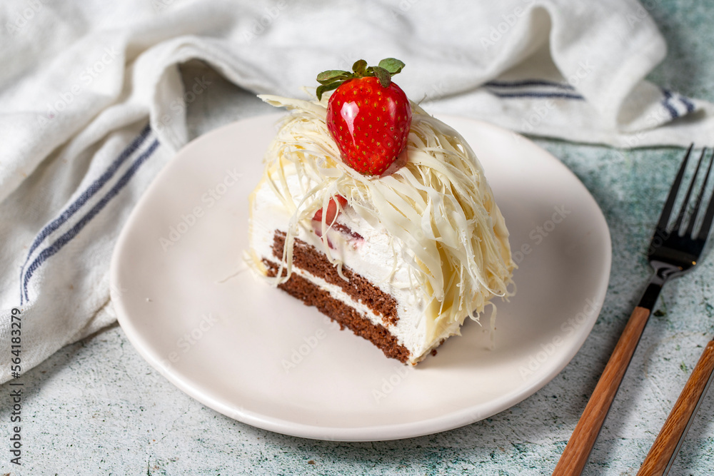 Layered white chocolate cake on a stone background. A slice of delicious strawberry cake. close up Layered white chocolate cake on a stone background. A slice of delicious strawberry cake. close up
