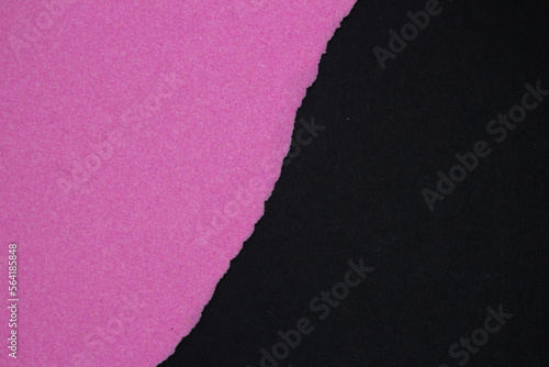 Pink torn paper on black background. Top view, copy space.