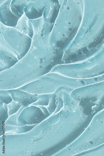 Transparent serum gel with hyaluronic acid for the face on a blue background. The texture of a cosmetic product with oxygen bubbles. Wellness and beauty concept.