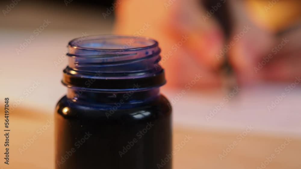A girl sits at the table and writes with a pen and ink. Calligraphy, handwriting correction, beautiful writing. Close-up A girl sits at the table and writes with a pen and ink. Calligraphy, handwriting correction, beautiful writing. Close-up