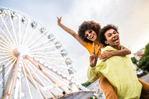 Bild auf Leinwand Multiracial young couple of lovers dating at theferry wheel in the amusement par