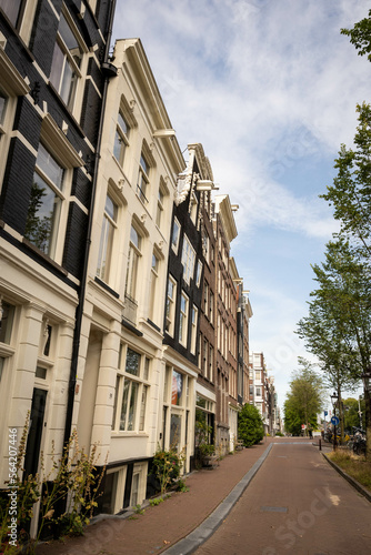 Residential houses on nieuwe herengracht near the Jewish quarter in Amsterdam Netherlands with Portugese synagoge and statue for Jonas Daniel Meijer in square photo