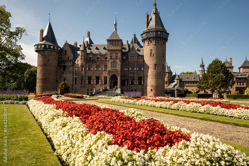 Fototapeta premium outside of Kasteel De Haar Dutch medieval castle with floral garden on sunny summer day. Flowers match colour of Utrecht Netherlands where historic building with European architecture is located 