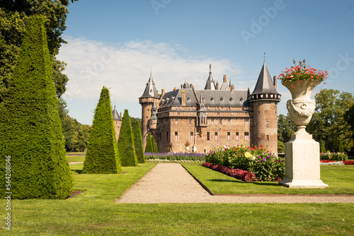 outside of Kasteel De Haar Dutch medieval castle with floral garden on sunny summer day. Flowers match colour of Utrecht Netherlands where historic building with European architecture is located 