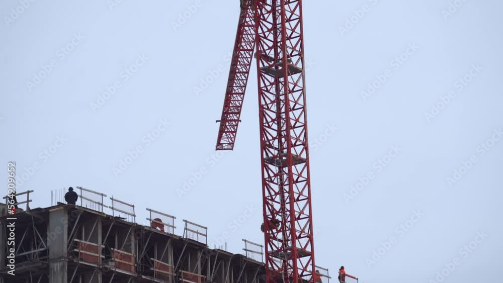 The work of a tower crane on the construction of a house The work of a tower crane on the construction of a house