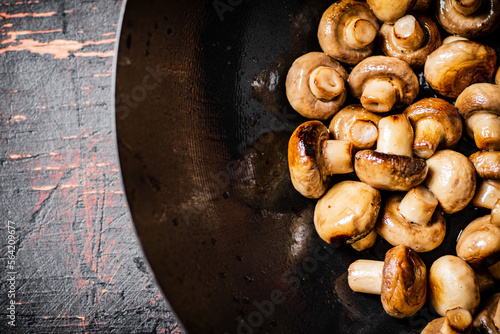 Fried small mushrooms in a frying pan. 