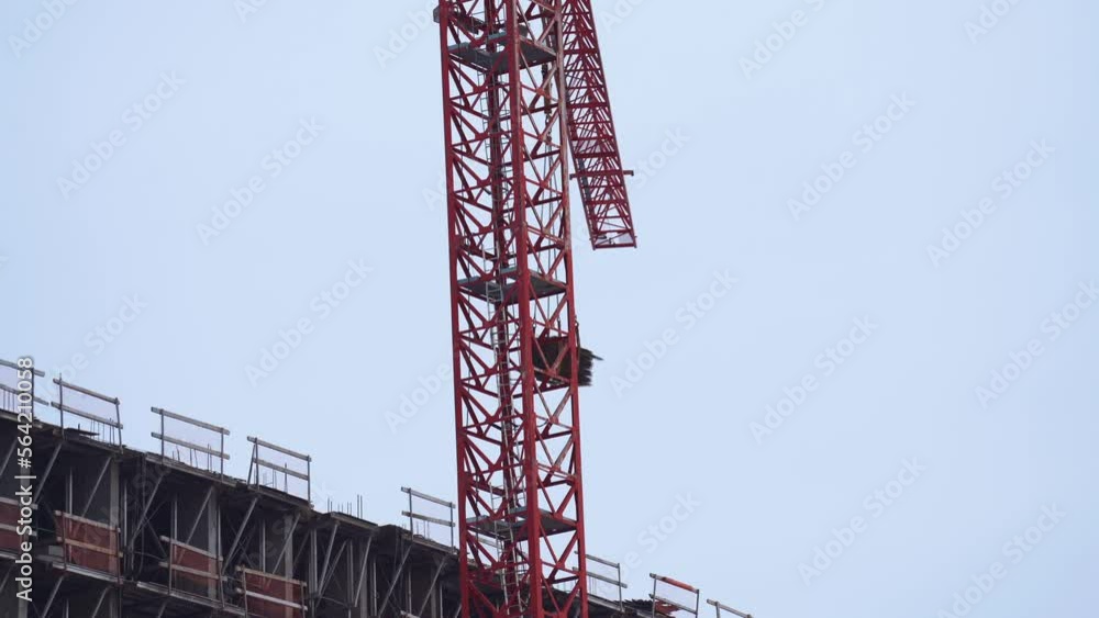 The work of a tower crane on the construction of a house The work of a tower crane on the construction of a house