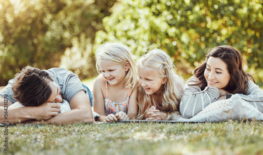 Fototapeta premium Family, parents and children at park, grass and garden in sunshine. Kids, mom and dad smile on lawn for love, laughing and fun in nature, backyard and summer vacation to relax together with happiness