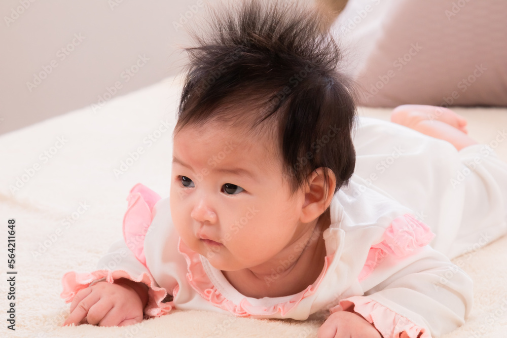 Portrait asian newborn baby 3 month lying prone on beige soft bed. healthy adorable infant without clothes looking for mom want to play with mother while she work, baby feel hungry want milk. Portrait asian newborn baby 3 month lying prone on beige soft bed. healthy adorable infant without clothes looking for mom want to play with mother while she work, baby feel hungry want milk.