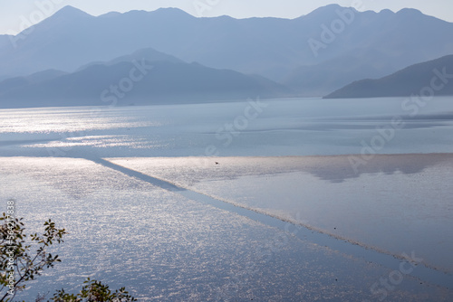 Scenic view on beautiful lake of Skadar National Park on sunny autumn day seen from Vranjina, Bar, Montenegro, Balkans, Europe. Travel destination, Dinaric Alps near Albania. Magical water reflection photo