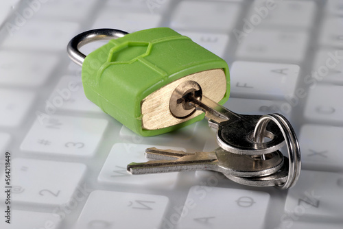 Green lock with keys on a computer keyboard, close-up, cyber security concept