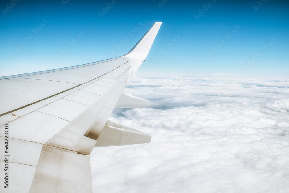 Fototapeta premium View from window of airplane on wing and blue sky with white clouds