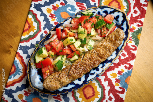 Traditional Turkish lyula kebab made of minced meat served on a plate with salad photo