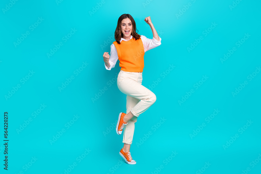 Full length photo of young successful business agent woman fists up celebrate much extra money payment isolated on aquamarine color background Full length photo of young successful business agent woman fists up celebrate much extra money payment isolated on aquamarine color background