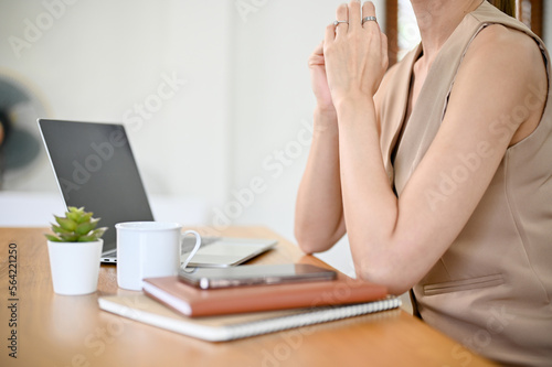 Asian businesswoman in casual clothes sits at her office desk. cropped  side view image