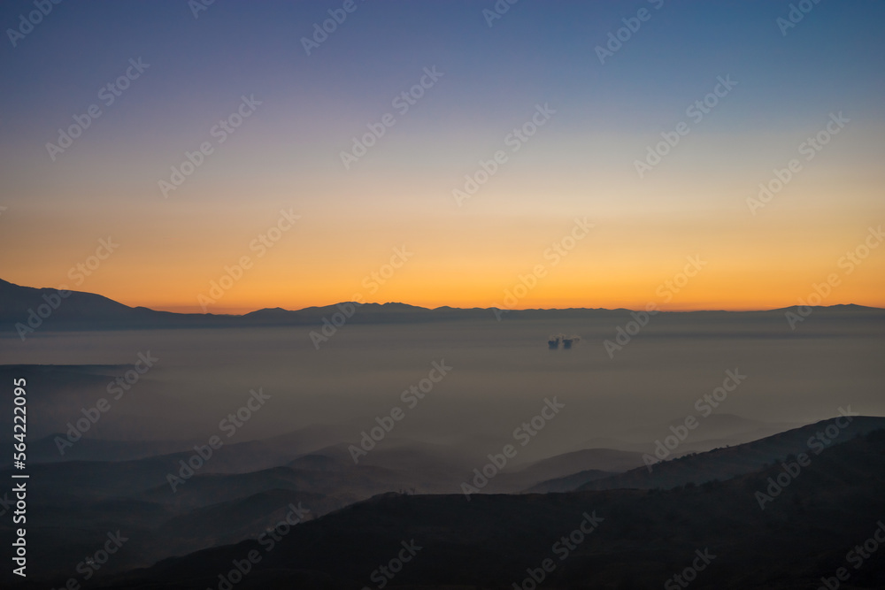 Colorful sunset shot in the mountains above the clouds on a winter day