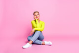Full length photo of lovely young lady sit floor dreamy crossed legs dressed stylish yellow garment isolated on pink color background