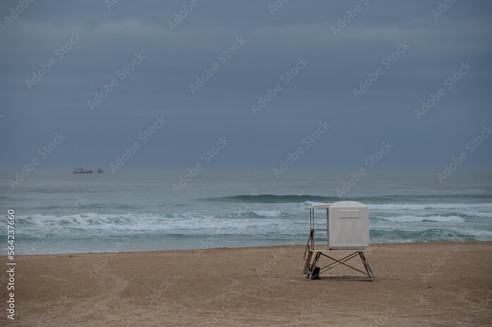 Empty beach with lifesavers hut seen on shore