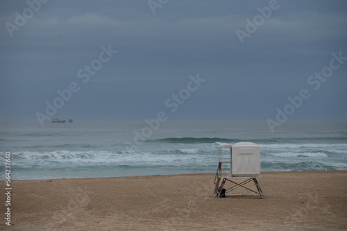 Empty beach with lifesavers hut seen on shore