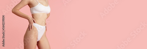 Fototapeta Naklejka Na Ścianę i Meble -  Cropped image of female body posing in cotton underwear. Slim fit body shape. Taking care after body. Concept of body and skin care, fitness, natural beauty, health. Banner, flyer. Copy space for ad