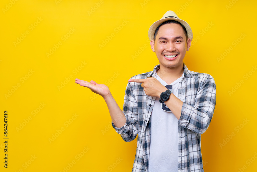 cheerful Young handsome ethnic Asian man 20s wearing casual clothes hat Pointing index finger and hand aside isolated on yellow background. People lifestyle concept cheerful Young handsome ethnic Asian man 20s wearing casual clothes hat Pointing index finger and hand aside isolated on yellow background. People lifestyle concept
