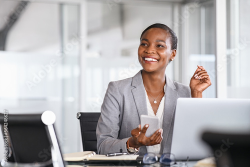 Foto Smiling businesswoman looking up while working