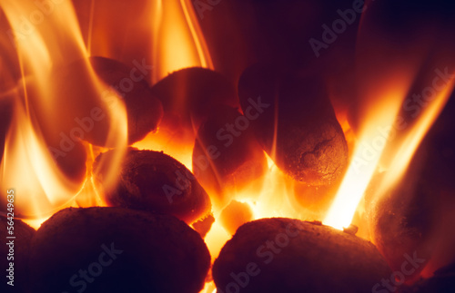 Obraz na płótnie A close up of fire and flames coming from smokeless fuel buring in a stove providing warmth and heat to the house. w salonie