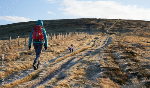 Obraz na płótnie A hiker and their dog at Windy Rig below the summit of Windy Gyle on a sunny but frosty winters morning sunrise in the Northumberland Cheviot mountains, UK. w salonie