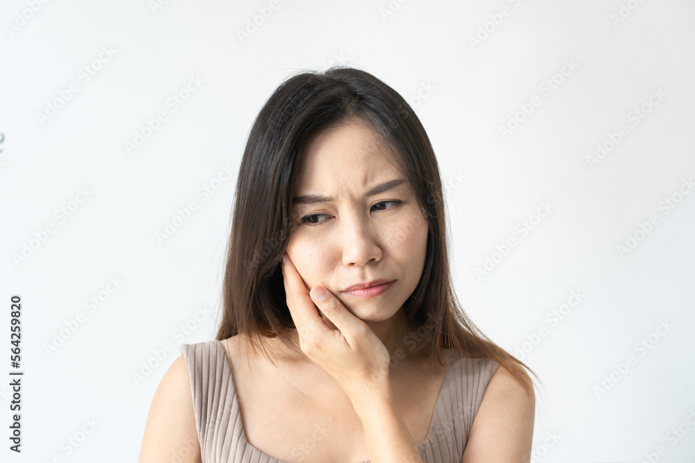 Young Asian woman feeling teeth pain. Close up of sad girl suffering from toothache on white background. Dental health and care, teeth problem concept. Copy space, closeup Young Asian woman feeling teeth pain. Close up of sad girl suffering from toothache on white background. Dental health and care, teeth problem concept. Copy space, closeup