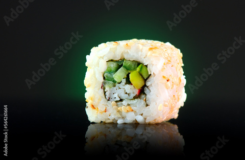 Vegetarian sushi roll Japanese food over dark background. Sushi roll with cucumber, avocado, vegetables closeup. Japan restaurant menu. Vegan 