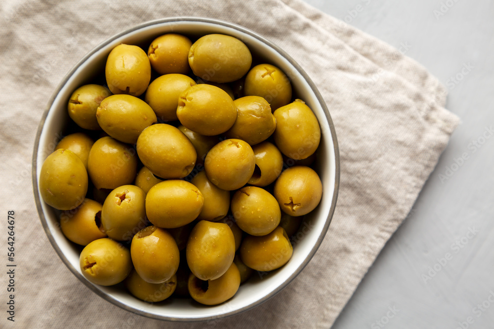 Marinated Green Pitted Olives in a Bowl, top view. Flat lay, overhead, from above. Copy space. Marinated Green Pitted Olives in a Bowl, top view. Flat lay, overhead, from above. Copy space.