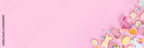Cute pink sweet baking flat lay for Easter holiday. Cooking background with baking ingredients, rolling pin, whisk for whipping, cookie and cutters, sugar sprinkling, flour, top view copy space
