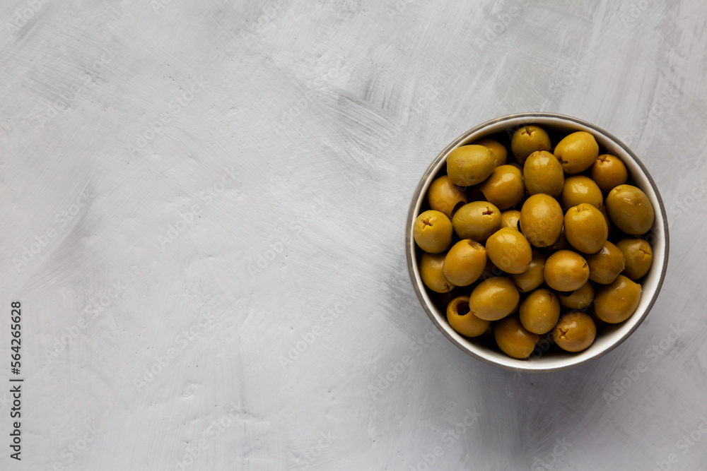 Marinated Green Pitted Olives in a Bowl, top view. Flat lay, overhead, from above. Space for text. Marinated Green Pitted Olives in a Bowl, top view. Flat lay, overhead, from above. Space for text.