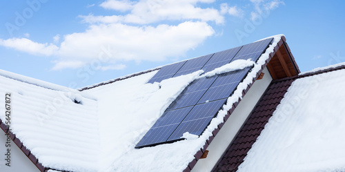 solar panels on the roof covered with snow in winter