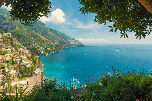 View on Italian coastal town Positano on Amalfi coast from terrace with flowers and trees, Campania, Italy