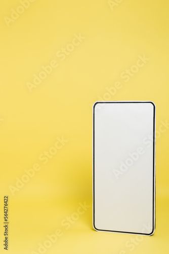 vertical view of white template of mobile phone on yellow background.