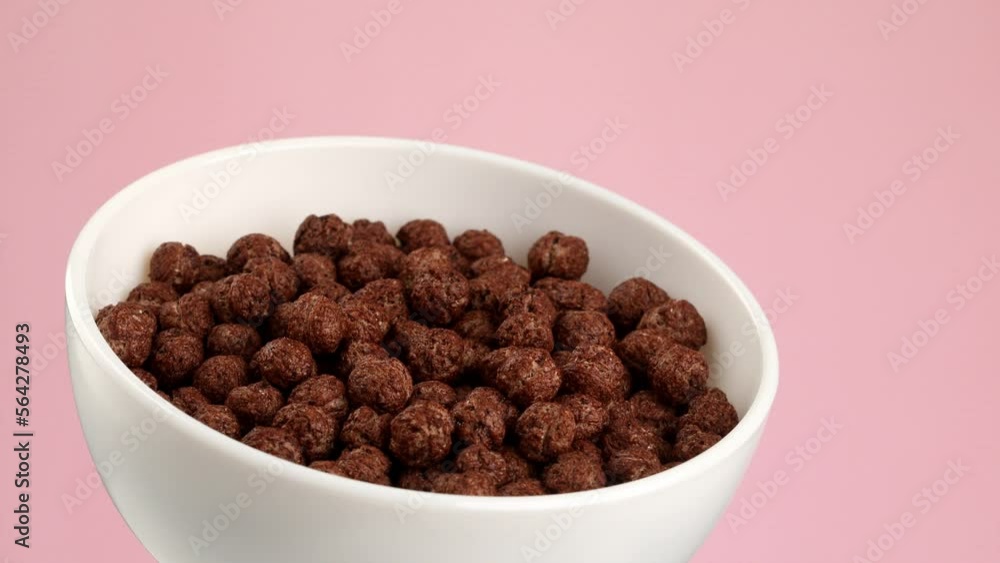 Bowl with chocolate balls. dry breakfast. crunchy corn balls with cocoa on pink background. Bowl with chocolate balls. dry breakfast. crunchy corn balls with cocoa on pink background.