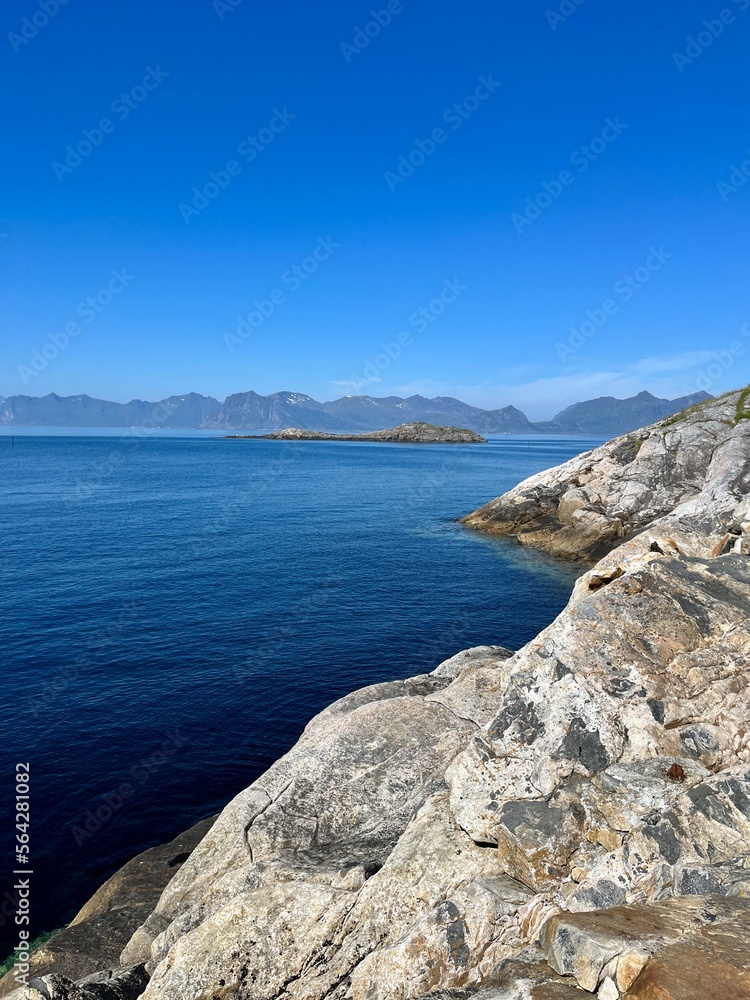 Blue calm ocean bay horizon, small rocky islands, blue sky