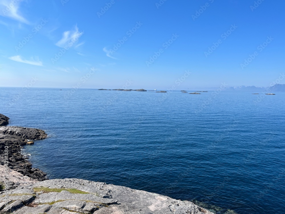 Blue calm ocean bay horizon, small rocky islands, blue sky