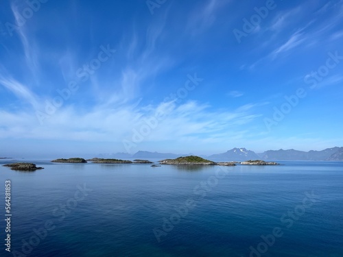 фотография Blue calm ocean bay horizon, small rocky islands, blue sky