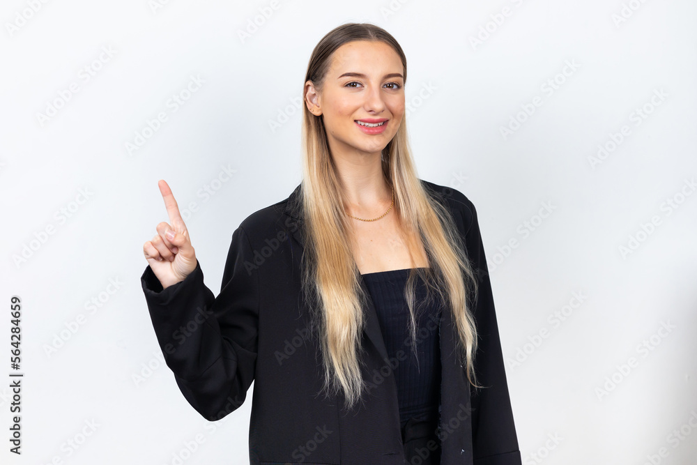 Female pointing up and looking at camer. Professional company business woman over white wall background Female pointing up and looking at camer. Professional company business woman over white wall background