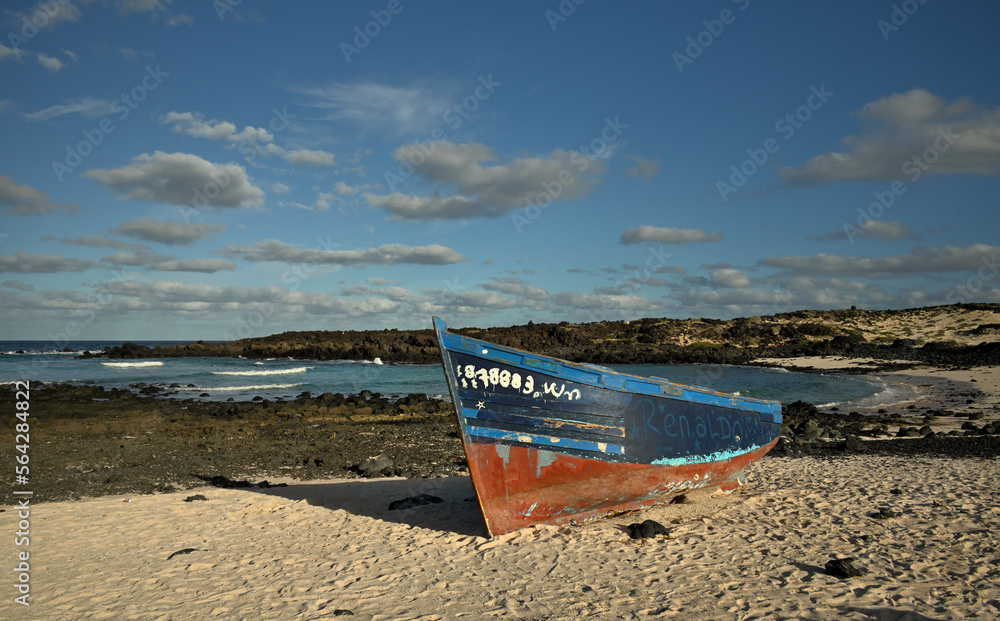 Ein Holzboot liegt verlassen an einem idyllischen Strand Ein Holzboot liegt verlassen an einem idyllischen Strand