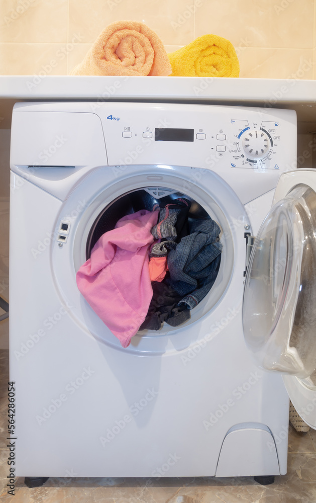 washing machine loaded with clothes . washing machine loaded with clothes .
