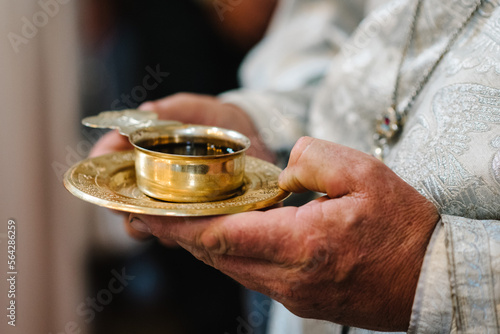 The priest blesses and hold cup the blood of God, wine. Priest celebrate a mass at the church. traditional wedding ceremony. Sacred cup for the wedding ceremony.