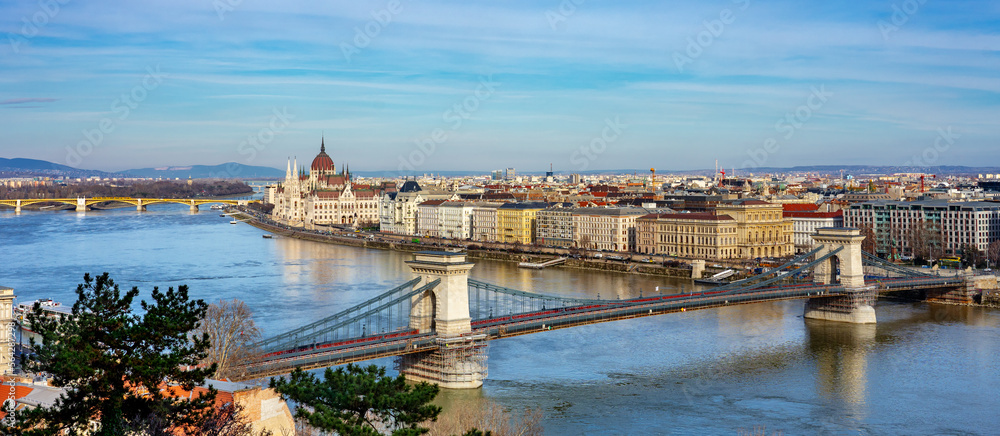 Panoramic photo about Danube river bank in Budapest Hungary with parliament and chain szechenyi bridge