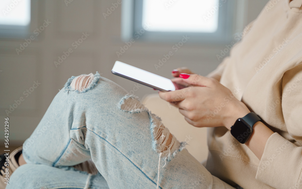 Close up of caucasian woman sitting on sofa in living room and touching tablet. Close up of caucasian woman sitting on sofa in living room and touching tablet.