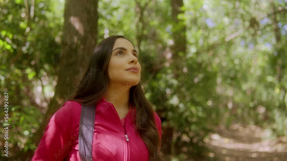 enjoy freedom in nature. thoughtful holiday maker with pink jacket looking surrounding trees in forest trail. enjoy freedom in nature. thoughtful holiday maker with pink jacket looking surrounding trees in forest trail.
